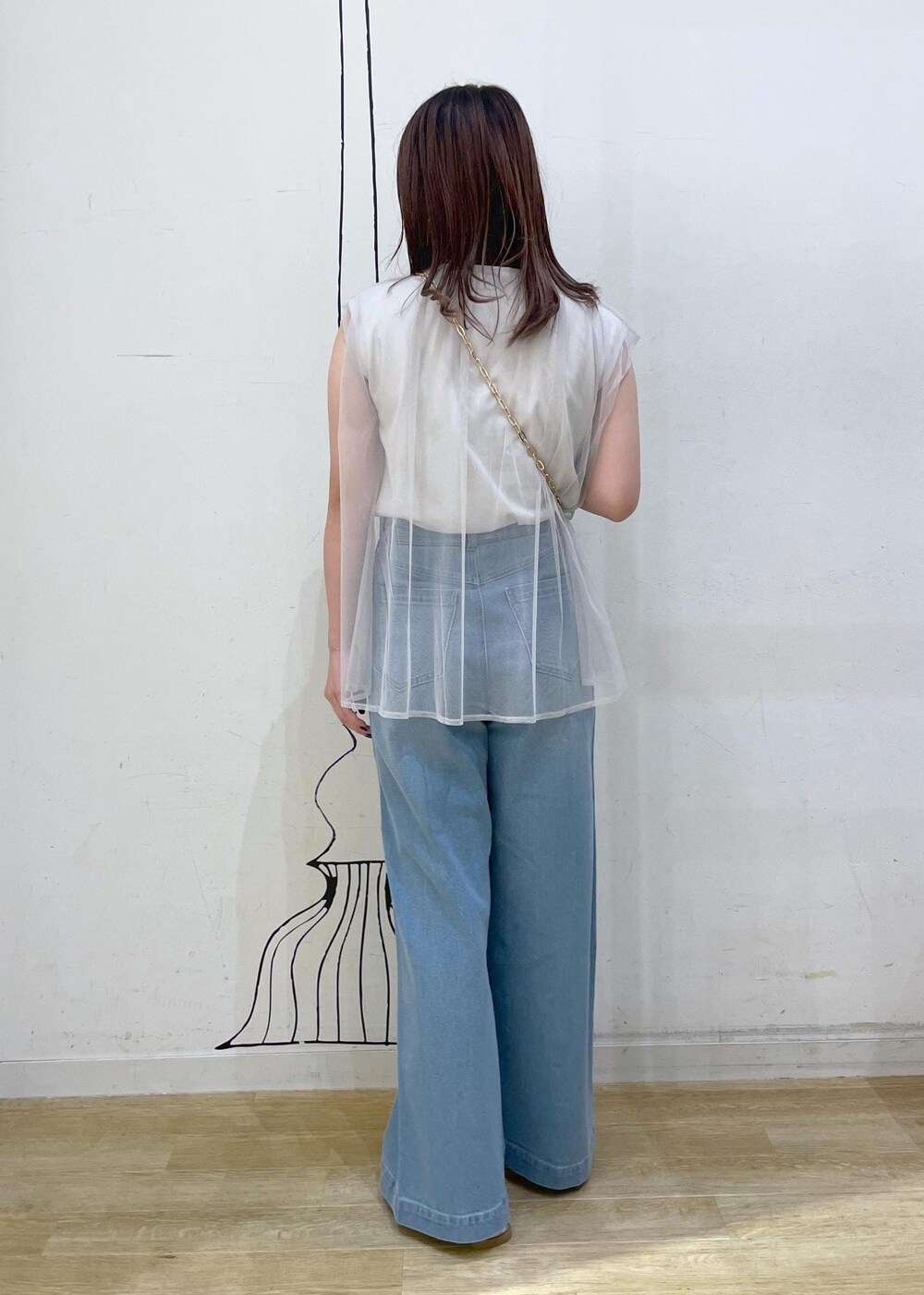 ブルー系のデニムパンツ、シルバー系のサンダル、グレー系のTシャツ/カットソーを着用したレディースの夏コーディネートの2枚目の写真