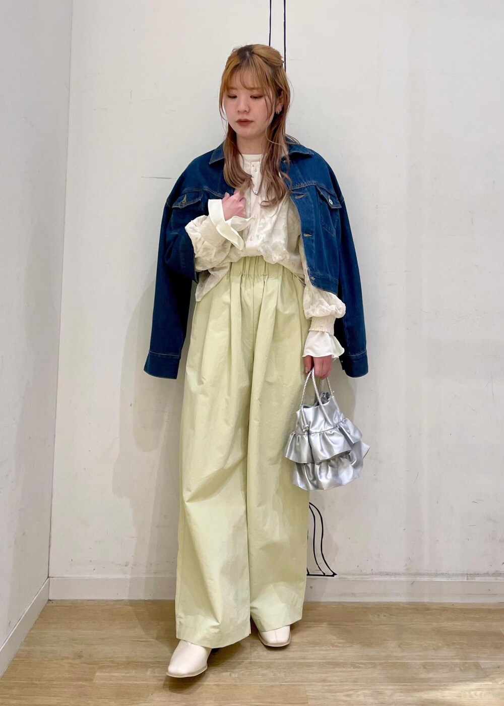 シルバー系のショルダーバッグ、ホワイト系のパンプス、ブルー系のデニムジャケットを着用したレディースの春コーディネートの7枚目の写真