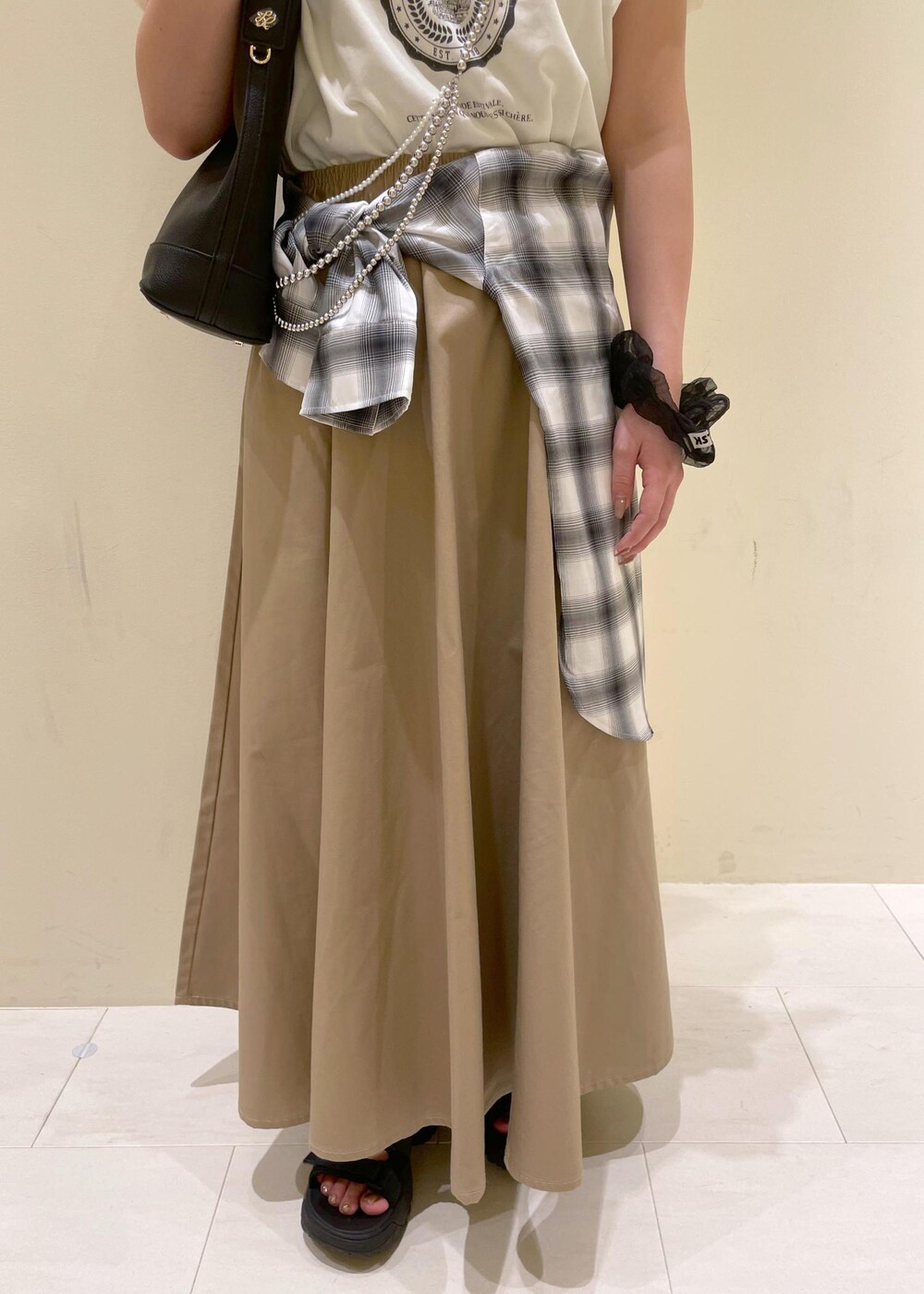 ブラック系のサンダル、ベージュ系のスカート、ホワイト系のシャツ/ブラウスを着用したレディースの夏コーディネートの8枚目の写真