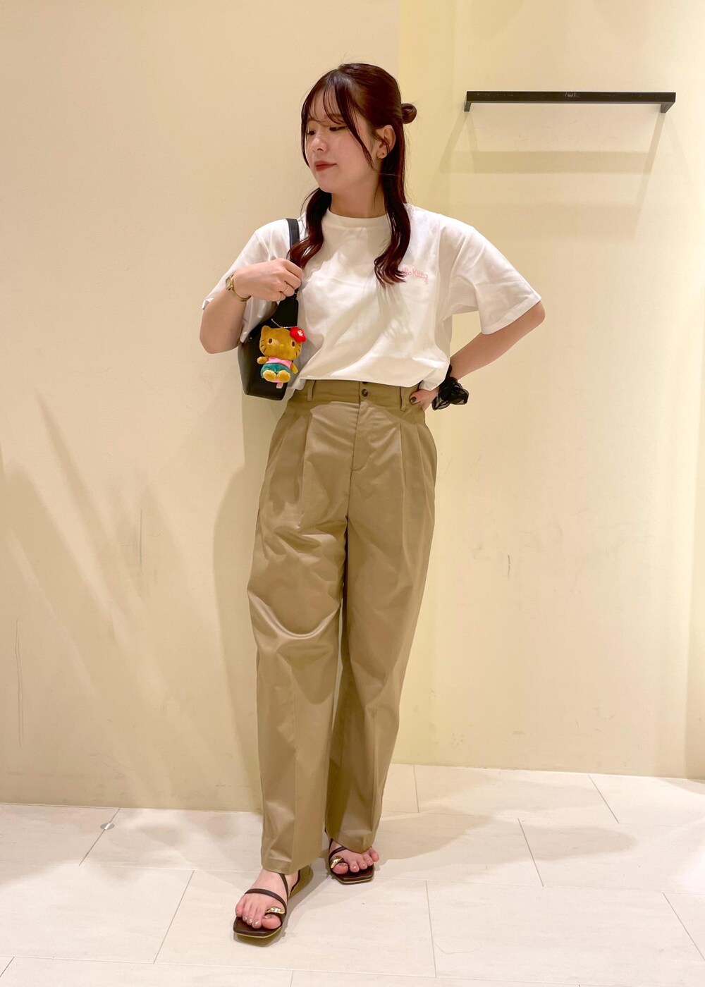 ベージュ系のチノパンツ、ブラウン系のサンダル、ブラック系のハンドバッグを着用したレディースの夏コーディネートの10枚目の写真
