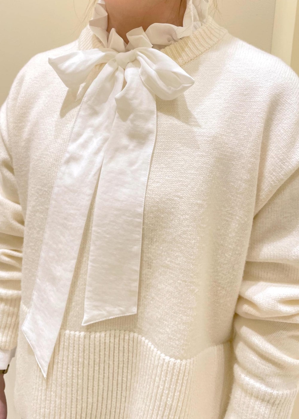 シルバー系のバレエシューズ、ホワイト系のニット/セーター、ホワイト系のトートバッグを着用したレディースの冬コーディネートの7枚目の写真