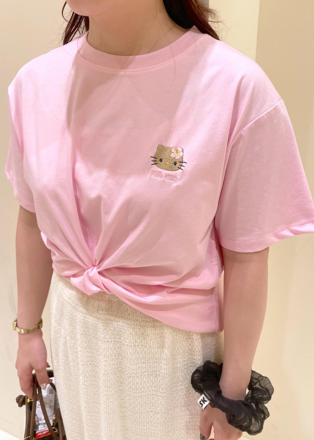 ホワイト系のスカート、ゴールド系のサンダル、ブラウン系のトートバッグを着用したレディースの夏コーディネートの5枚目の写真