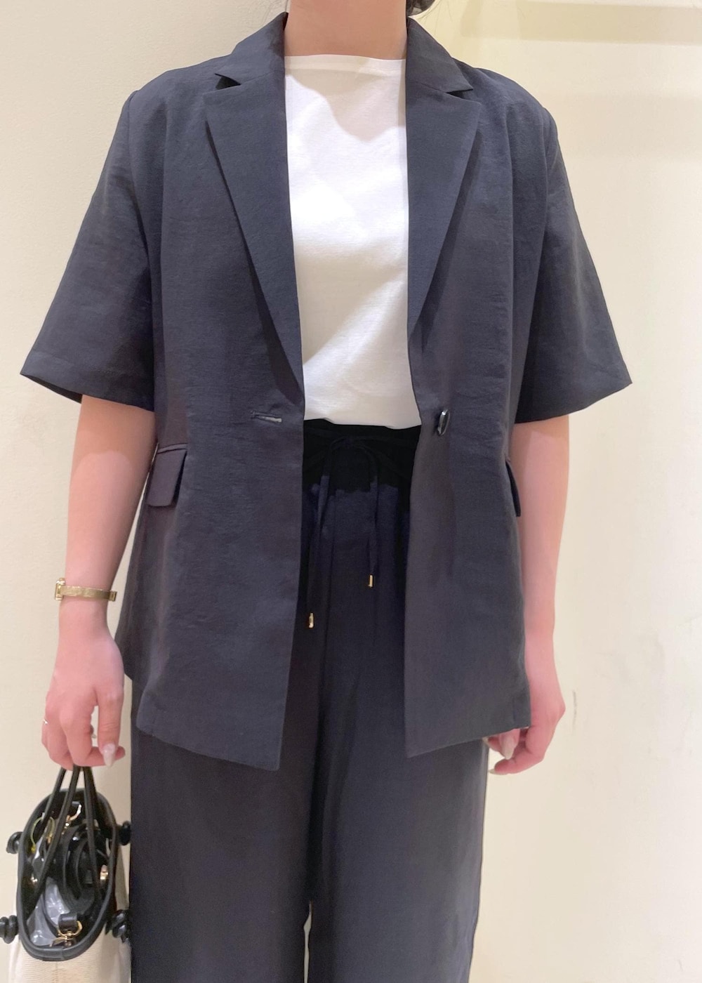 ホワイト系のTシャツ/カットソー、グレー系のその他パンツ、グレー系のテーラードジャケットを着用したレディースの夏コーディネートの5枚目の写真