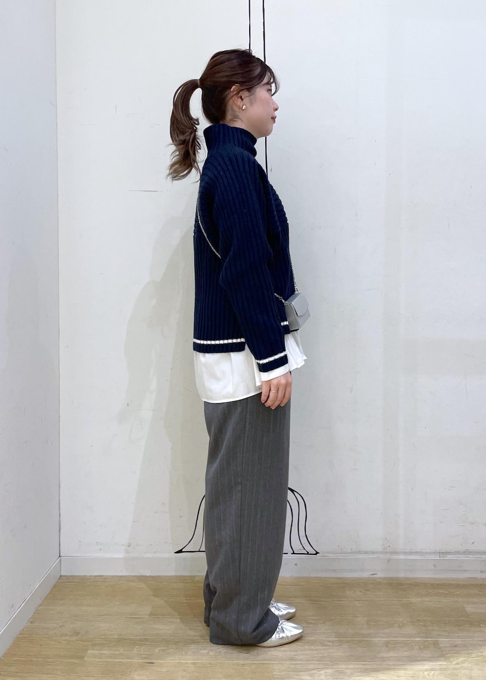 シルバー系のパンプス、ホワイト系のシャツ/ブラウス、ブルー系のニット/セーターを着用したレディースの秋コーディネートの3枚目の写真