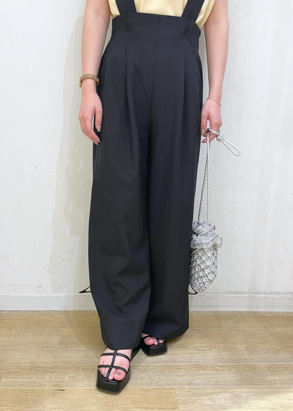 ベージュ系のニット/セーター、ブラック系のその他パンツ、ブラック系のサンダルを着用したレディースの夏コーディネートの6枚目の写真