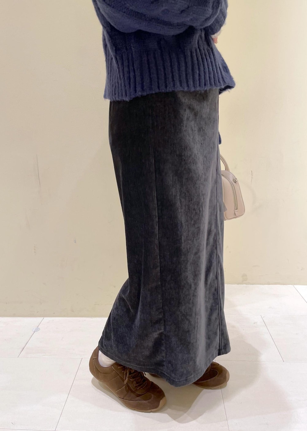 グレー系のスカート、ブルー系のカーディガン/ボレロ、ホワイト系のニット/セーターを着用したレディースの冬コーディネートの7枚目の写真