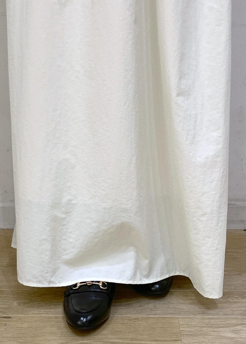 ブラック系のローファー、ホワイト系のスカート、グレー系のニット/セーターを着用したレディースの秋コーディネートの8枚目の写真