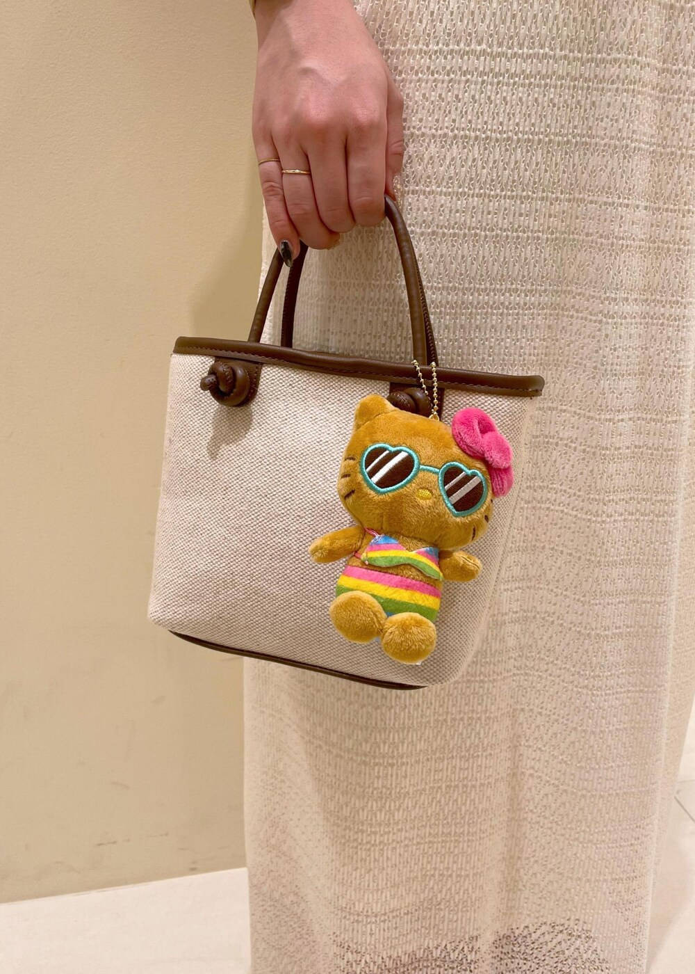 ホワイト系のスカート、ゴールド系のサンダル、ブラウン系のトートバッグを着用したレディースの夏コーディネートの9枚目の写真