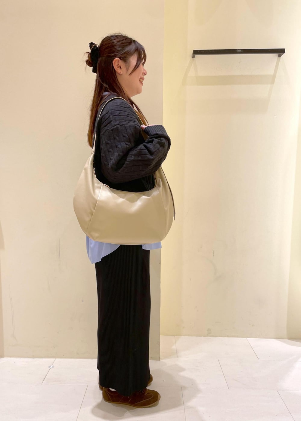 ブラック系のスカート、ブルー系のシャツ/ブラウス、グレー系のニット/セーターを着用したレディースの冬コーディネートの2枚目の写真