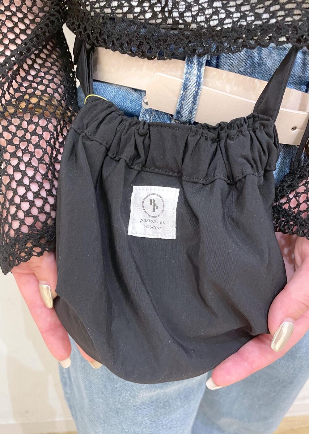 シルバー系のサンダル、ブラック系のショルダーバッグ、ホワイト系のタンクトップを着用したレディースの夏コーディネートの8枚目の写真