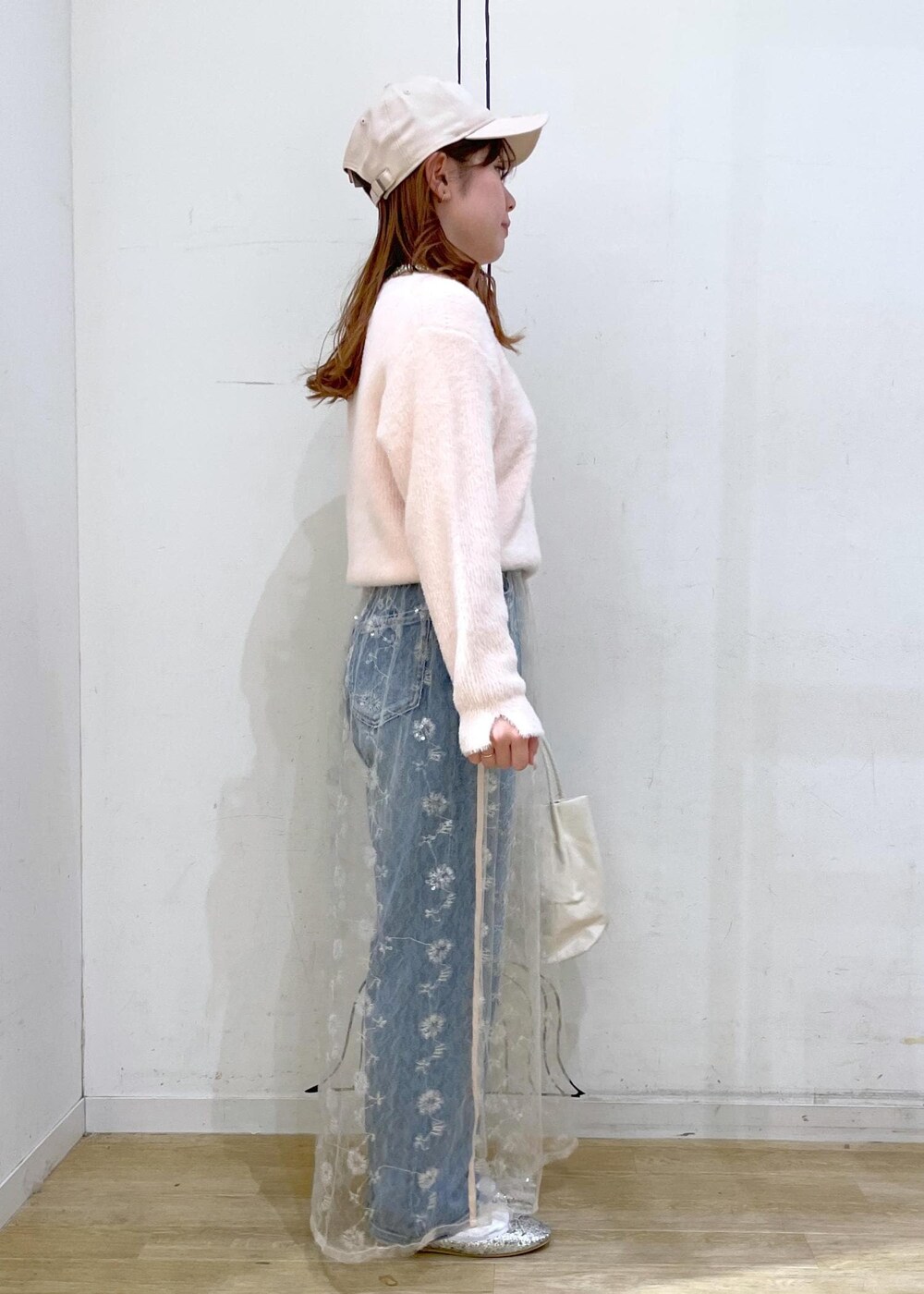 ホワイト系のスカート、シルバー系のバレエシューズ、ブルー系のデニムパンツを着用したレディースの冬コーディネートの3枚目の写真