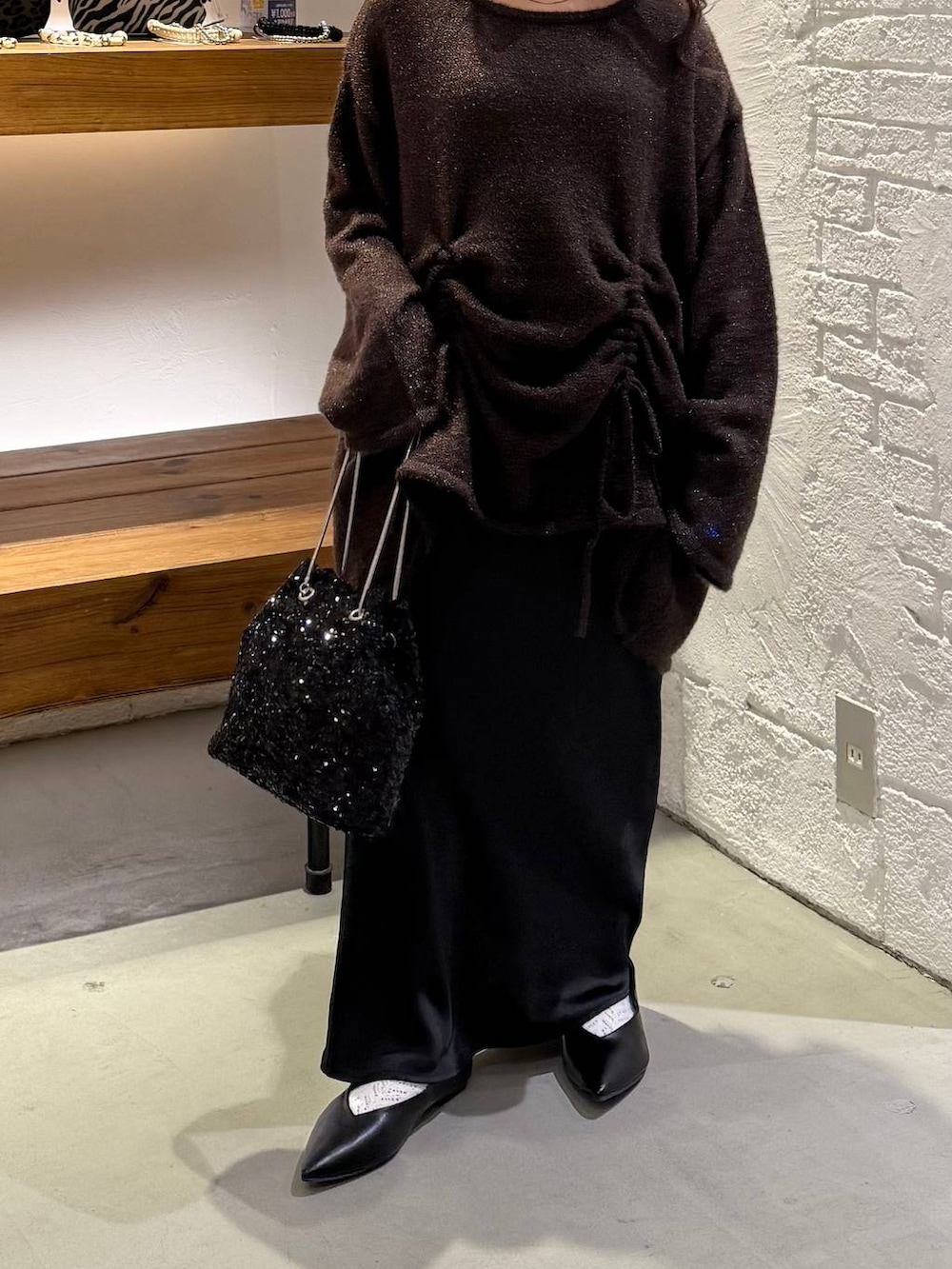 ブラック系のスカート、ブラック系のショルダーバッグ、ブラック系のパンプスを着用したレディースの冬コーディネートの3枚目の写真