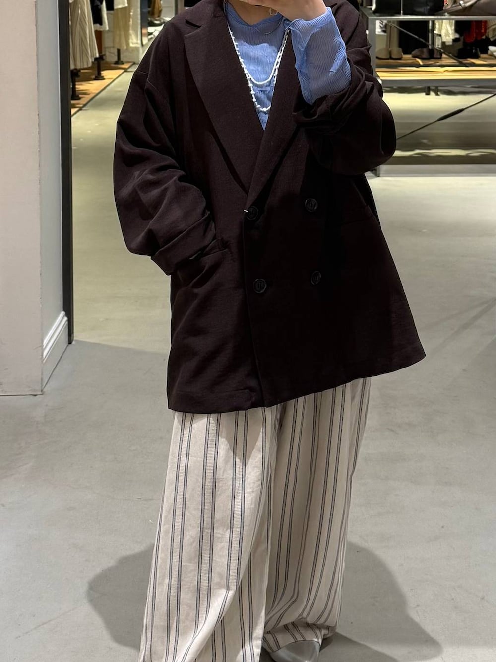 ブラウン系のテーラードジャケット、ブルー系のTシャツ/カットソー、シルバー系のパンプスを着用したレディースの春コーディネートの4枚目の写真