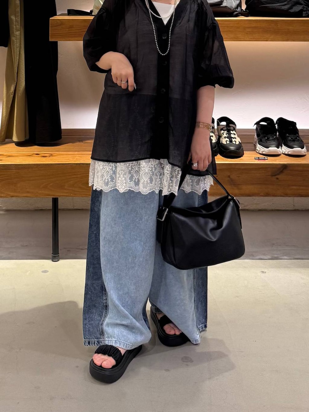 ブルー系のデニムパンツ、ブラック系のサンダル、ブラック系のシャツ/ブラウスを着用したレディースの夏コーディネートの4枚目の写真