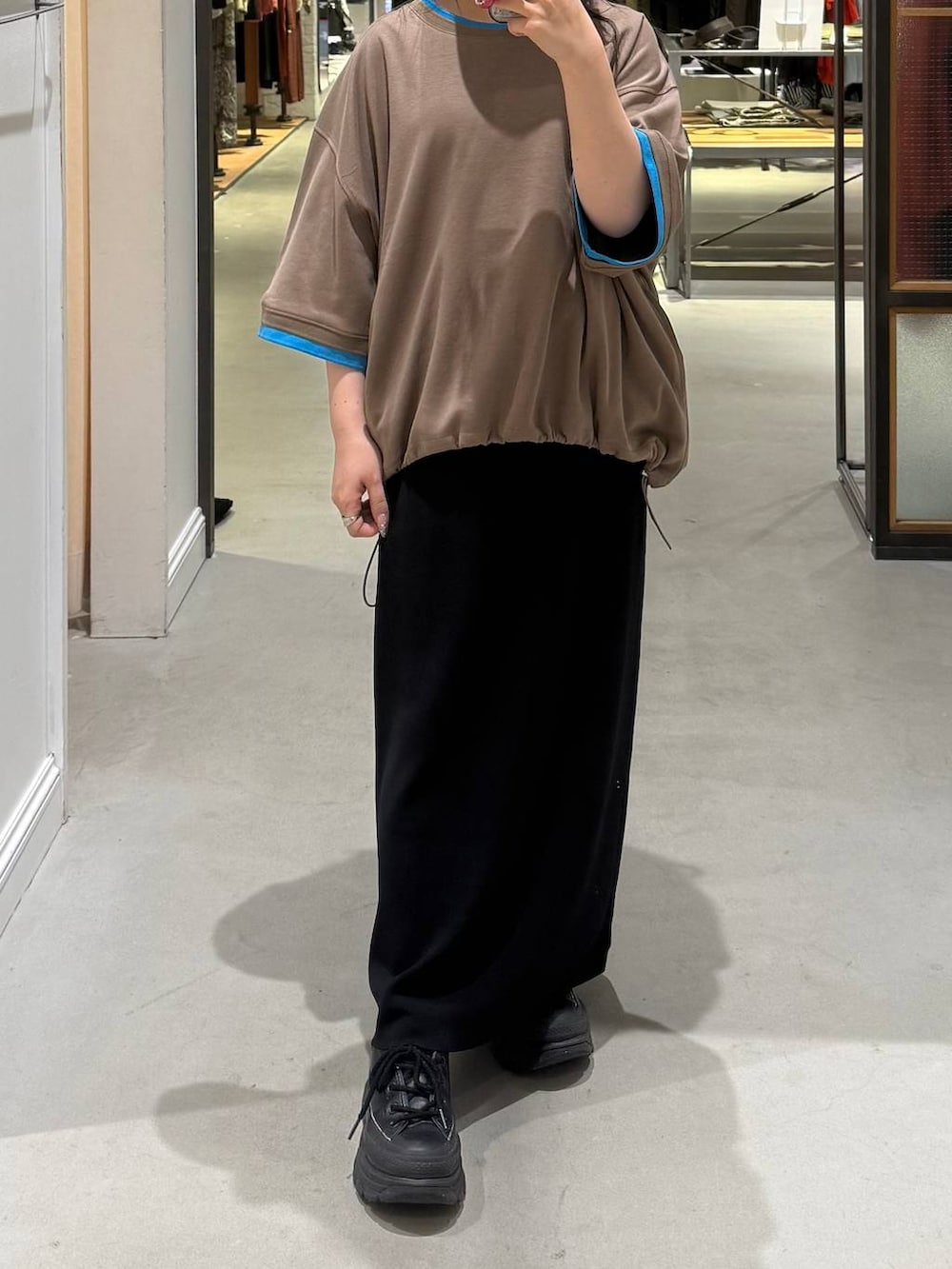 ブラック系のスカート、ブラウン系のTシャツ/カットソーを着用したレディースの春コーディネートの2枚目の写真