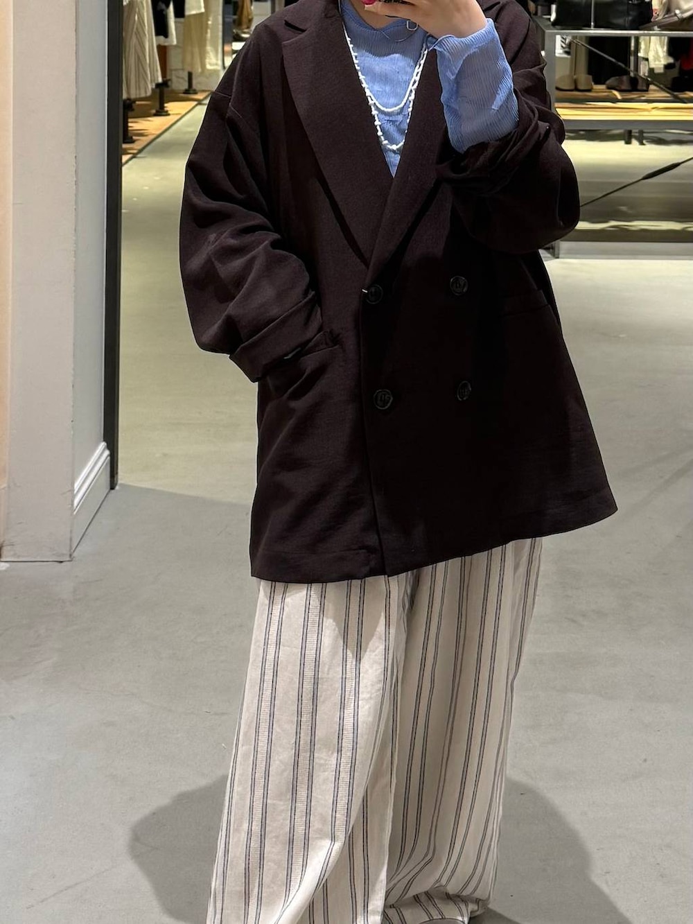 ブラウン系のテーラードジャケット、ブルー系のTシャツ/カットソー、シルバー系のパンプスを着用したレディースの春コーディネートの2枚目の写真