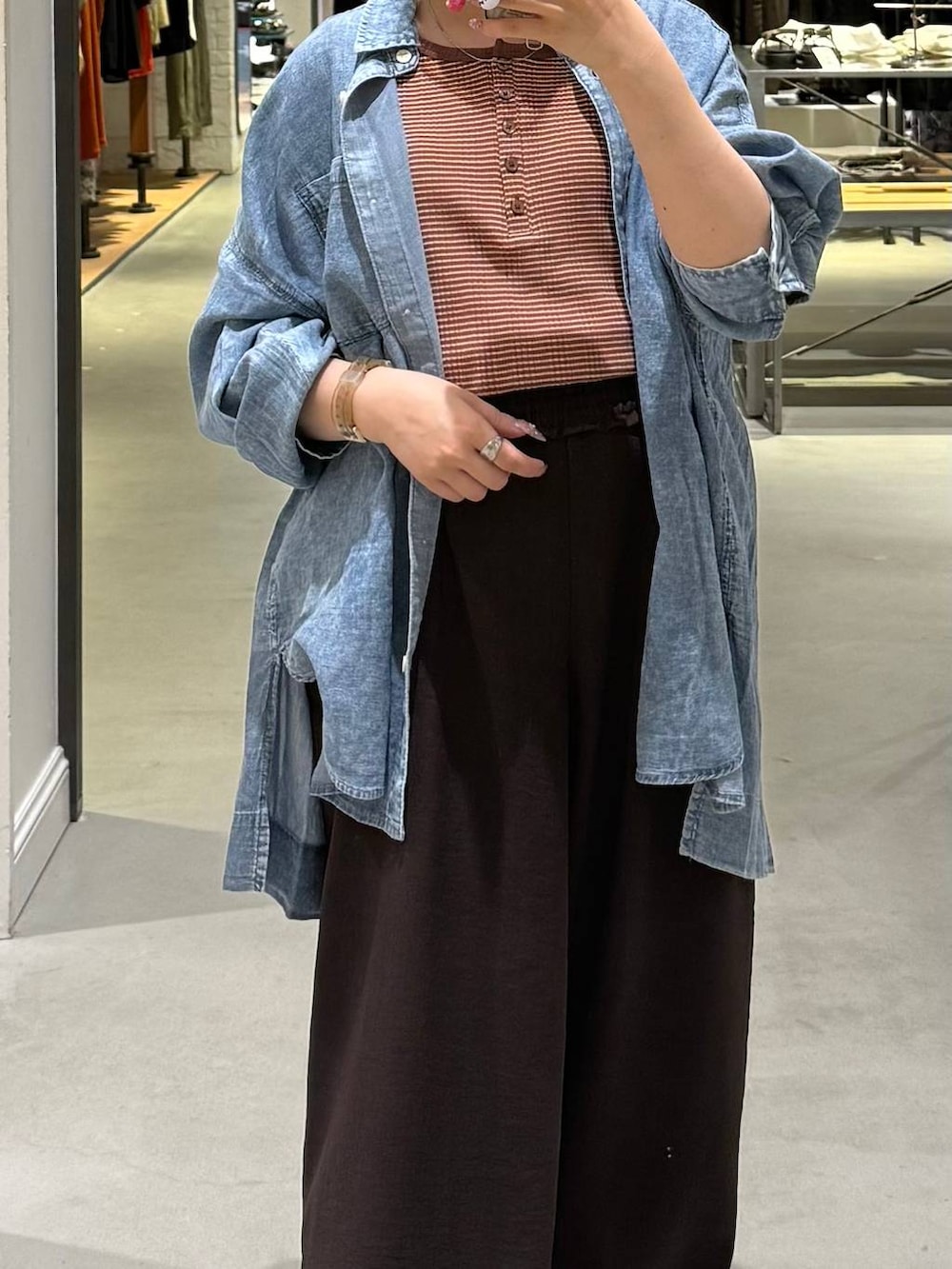 ブラック系のサンダル、ブラウン系のその他パンツ、ブルー系のシャツ/ブラウスを着用したレディースの春コーディネートの2枚目の写真