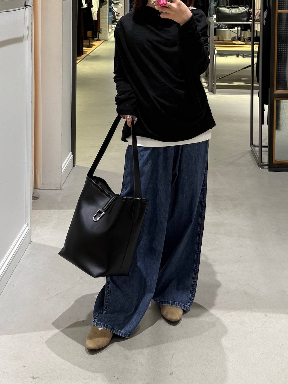 ブルー系のデニムパンツ、ブラック系のトートバッグ、ベージュ系のパンプスを着用したレディースの春コーディネートの2枚目の写真