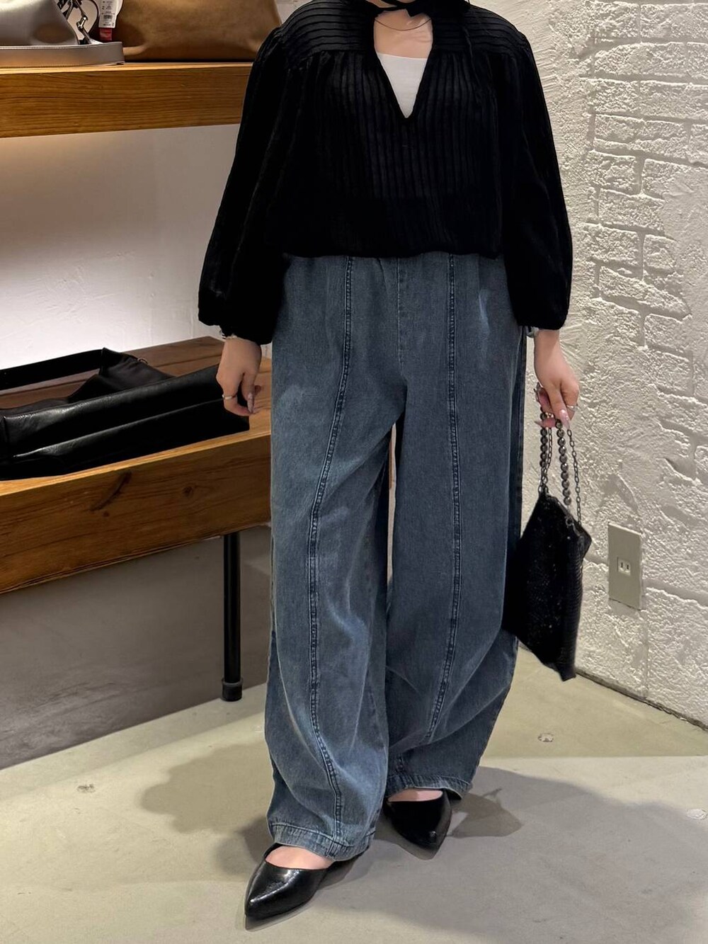 ブラック系のシャツ/ブラウス、ブラック系のショルダーバッグ、ブラック系のパンプスを着用したレディースの春コーディネートの5枚目の写真