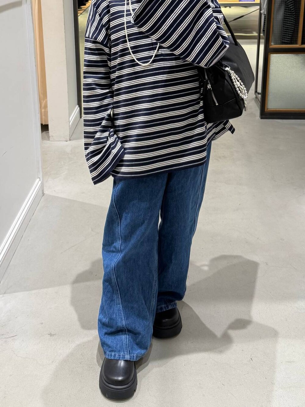 ブルー系のデニムパンツ、ブラック系のボストンバッグ、ブラック系のその他シューズを着用したレディースの冬コーディネートの2枚目の写真