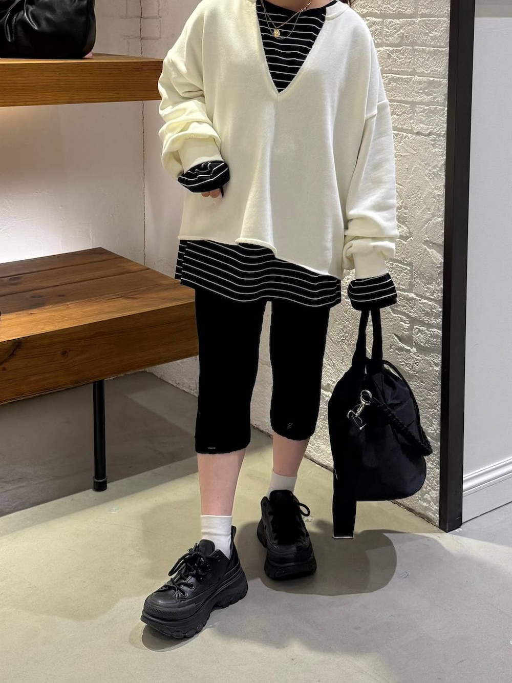 ブラック系のショルダーバッグ、ブラック系のTシャツ/カットソー、ブラック系のその他パンツを着用したレディースの冬コーディネートの3枚目の写真