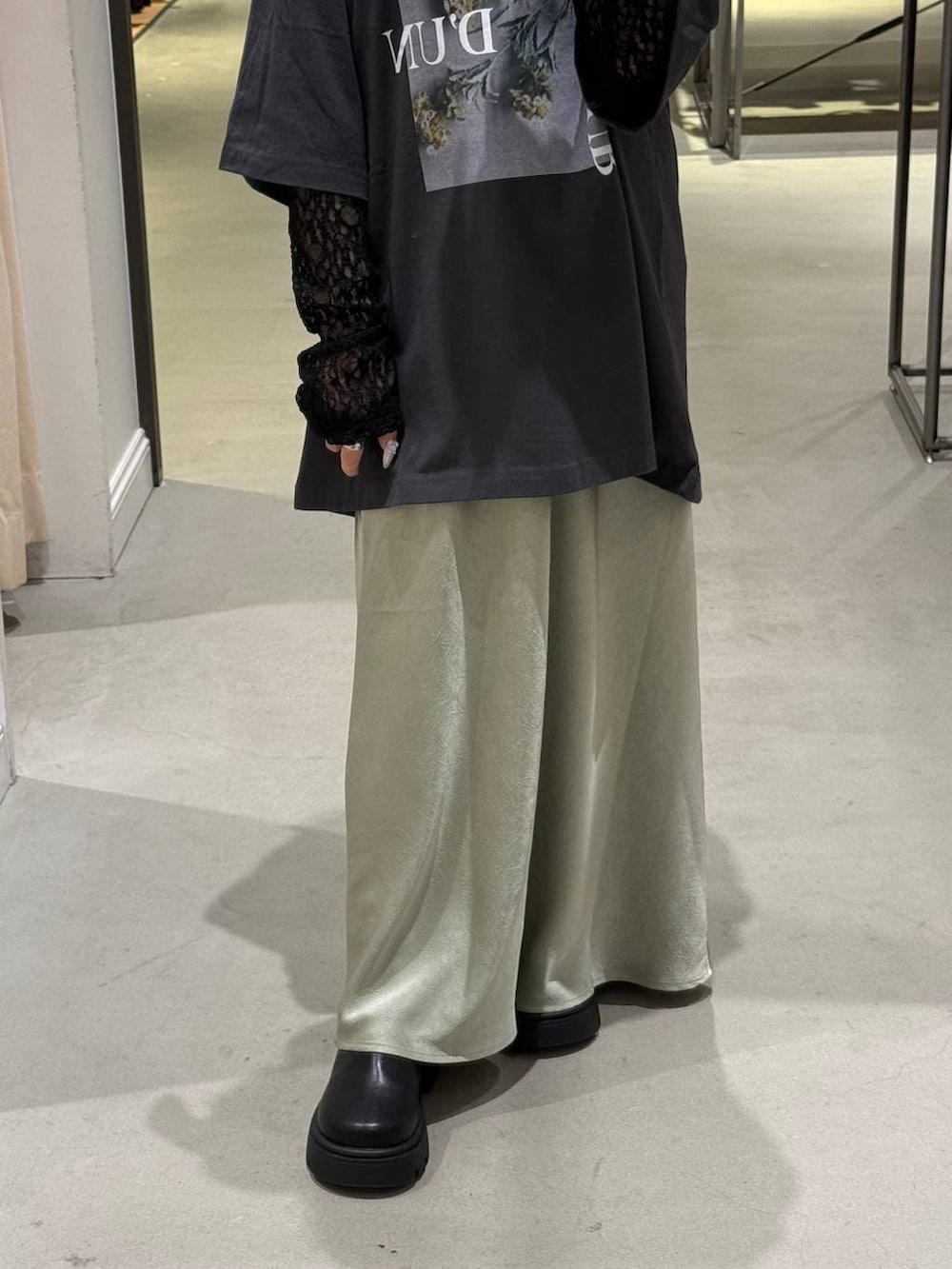 ブラック系のその他シューズ、グレー系のTシャツ/カットソー、グリーン系のスカートを着用したレディースの春コーディネートの2枚目の写真