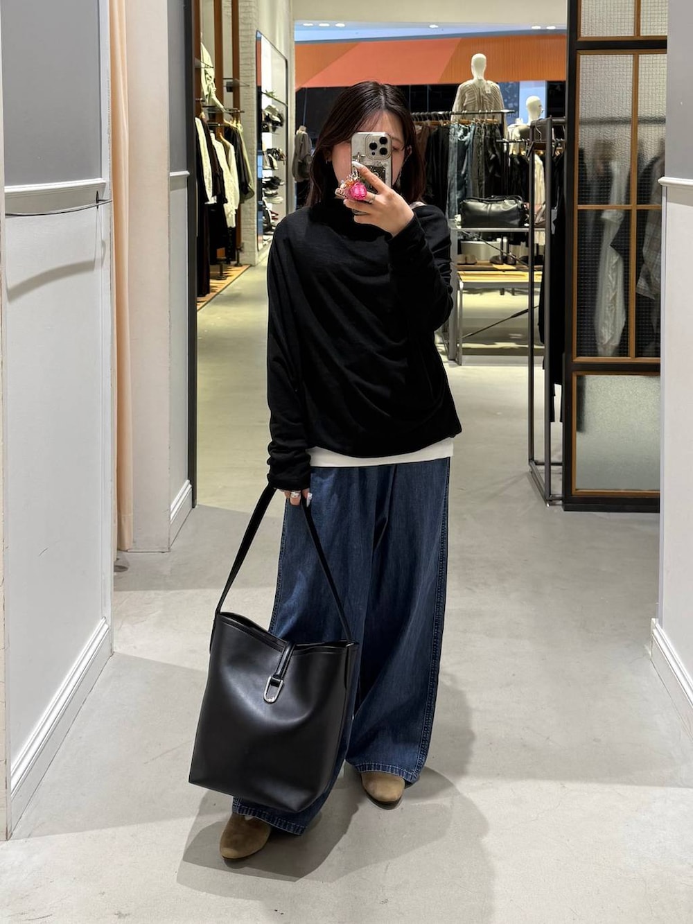 ブルー系のデニムパンツ、ブラック系のトートバッグ、ベージュ系のパンプスを着用したレディースの春コーディネートの5枚目の写真