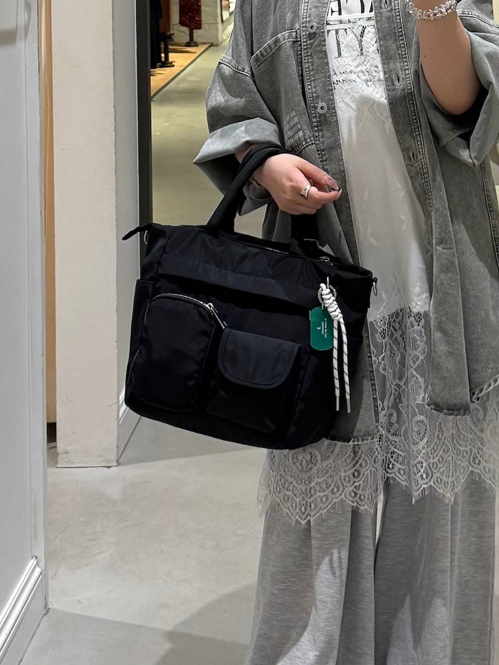 グレー系のその他パンツ、ブラック系のトートバッグ、グリーン系のシャツ/ブラウスを着用したレディースの春コーディネートの5枚目の写真