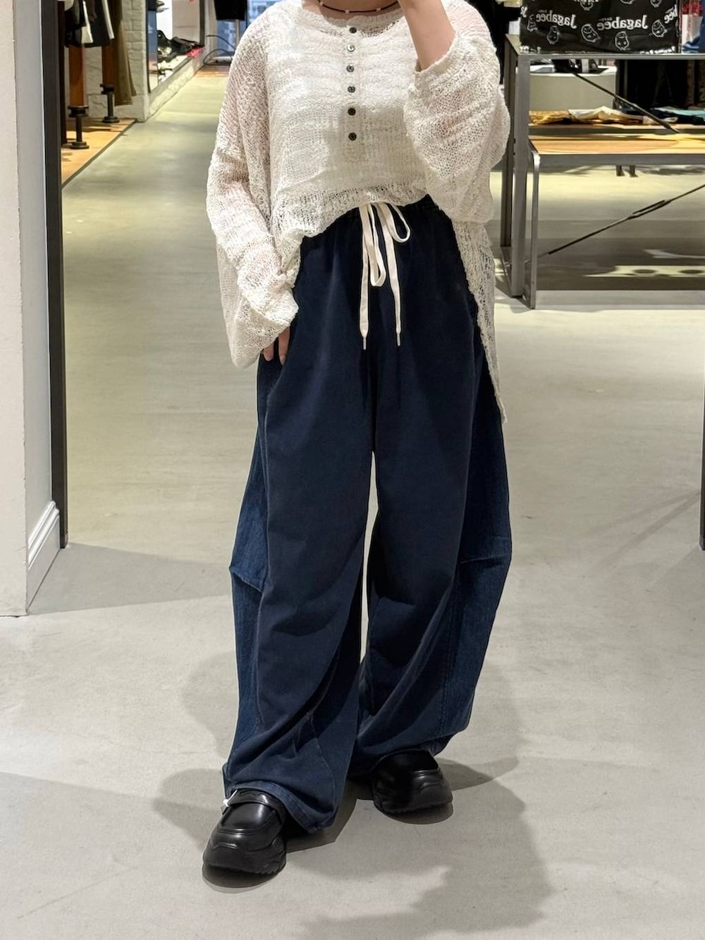 ブルー系のデニムパンツ、ブラック系のローファー、ホワイト系のニット/セーターを着用したレディースの夏コーディネートの3枚目の写真