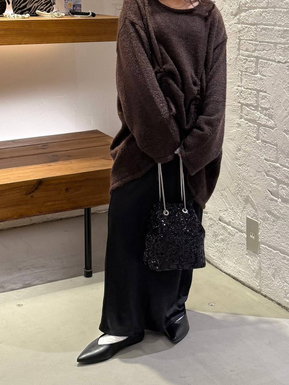 ブラック系のスカート、ブラック系のショルダーバッグ、ブラック系のパンプスを着用したレディースの冬コーディネートの2枚目の写真