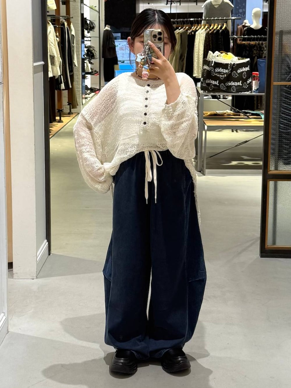 ブルー系のデニムパンツ、ブラック系のローファー、ホワイト系のニット/セーターを着用したレディースの夏コーディネートの4枚目の写真