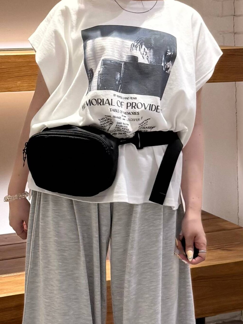 グレー系のその他パンツ、ブラック系のサンダル、ブラック系のボディバッグ/ウエストポーチを着用したレディースの夏コーディネートの2枚目の写真
