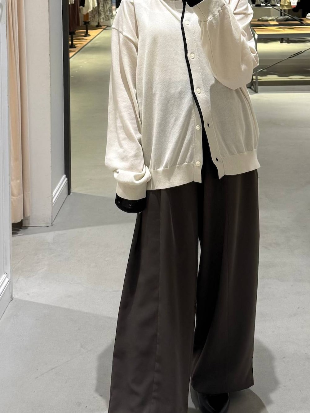 ブラウン系のその他パンツ、ブラック系のパンプス、ホワイト系のカーディガン/ボレロを着用したレディースの春コーディネートの2枚目の写真