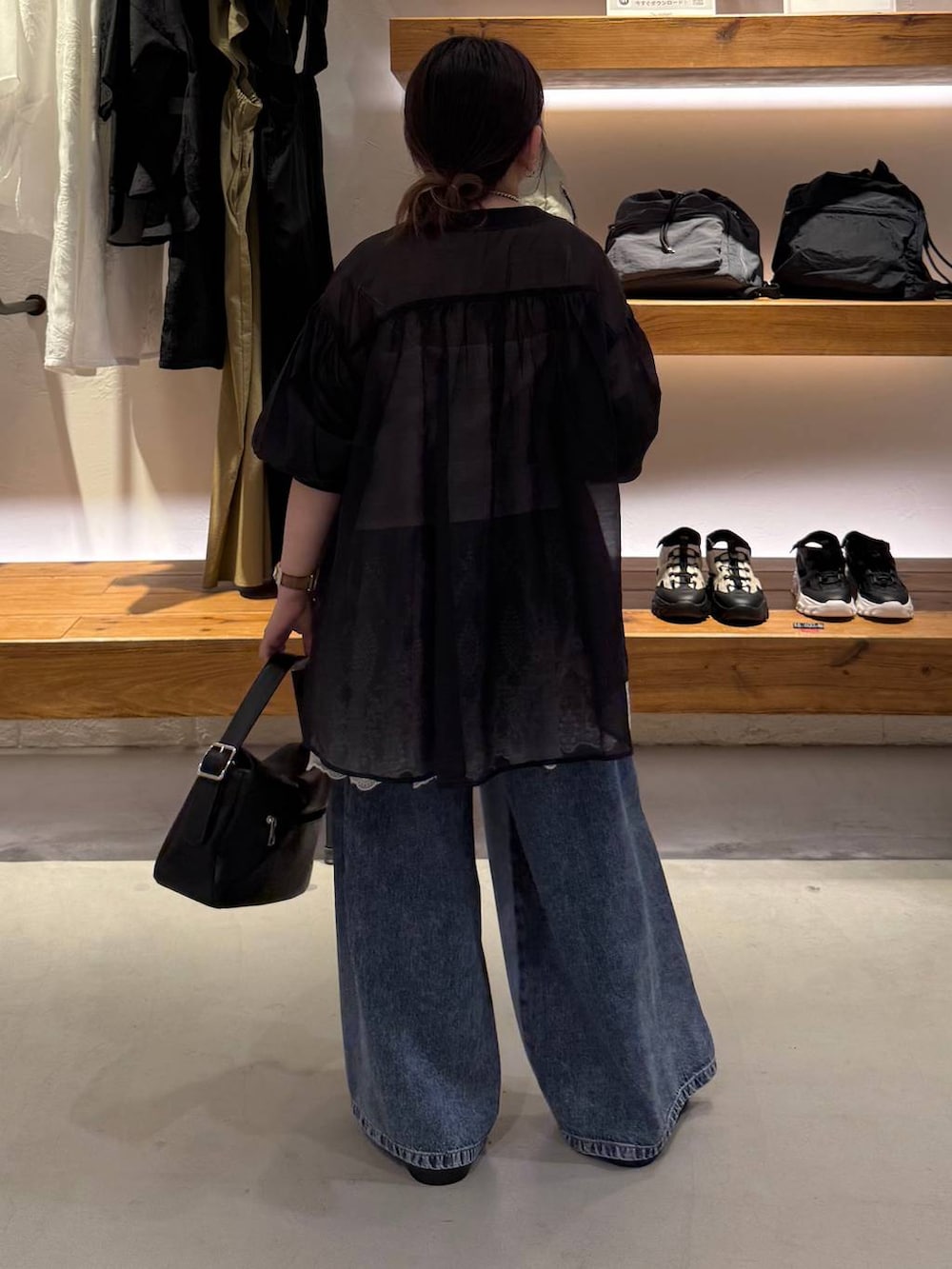 ブルー系のデニムパンツ、ブラック系のサンダル、ブラック系のシャツ/ブラウスを着用したレディースの夏コーディネートの3枚目の写真