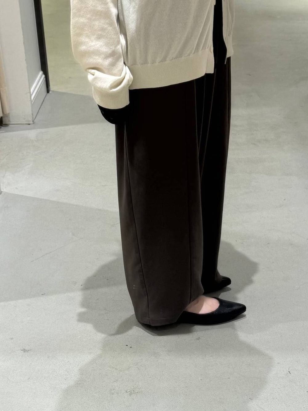 ブラウン系のその他パンツ、ブラック系のパンプス、ホワイト系のカーディガン/ボレロを着用したレディースの春コーディネートの3枚目の写真
