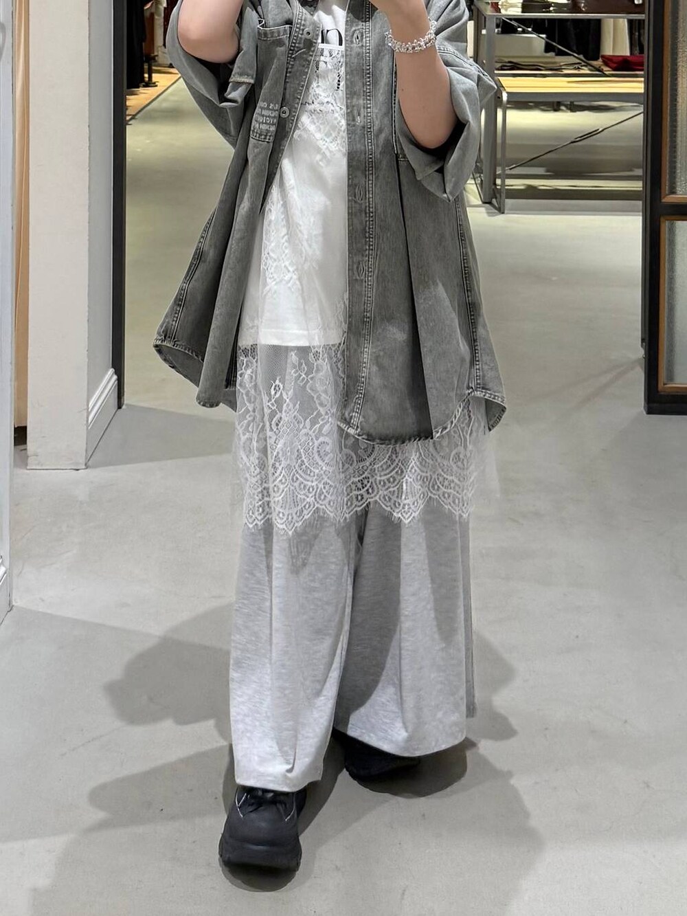 グレー系のその他パンツ、ブラック系のトートバッグ、グリーン系のシャツ/ブラウスを着用したレディースの春コーディネートの2枚目の写真