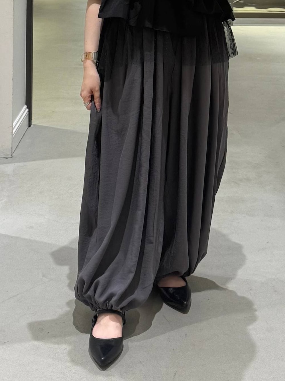 ブラック系のパンプス、グレー系のその他パンツ、ブラック系のTシャツ/カットソーを着用したレディースの春コーディネートの3枚目の写真