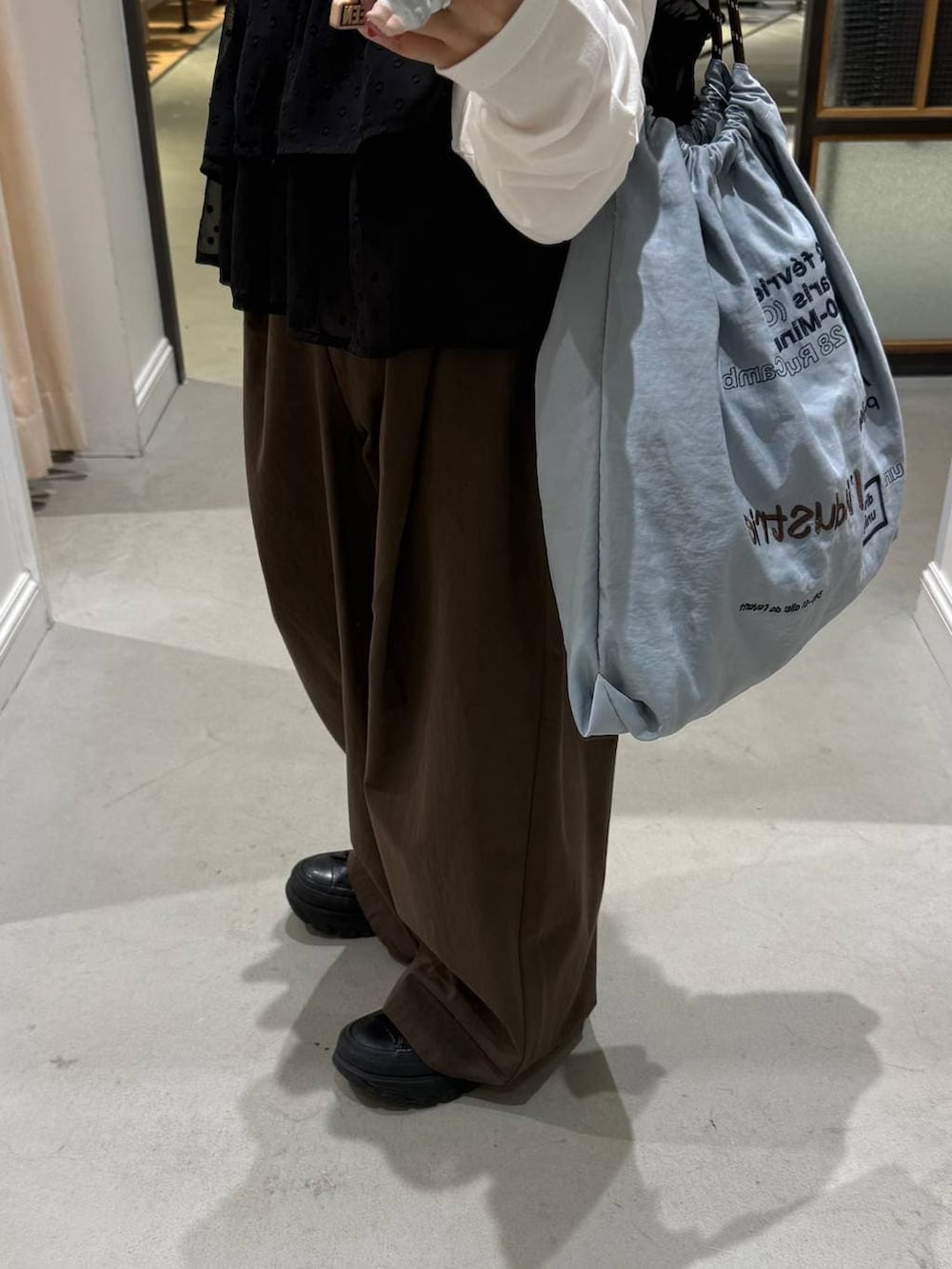 ブラウン系のその他パンツ、ブルー系のトートバッグを着用したレディースの冬コーディネートの3枚目の写真