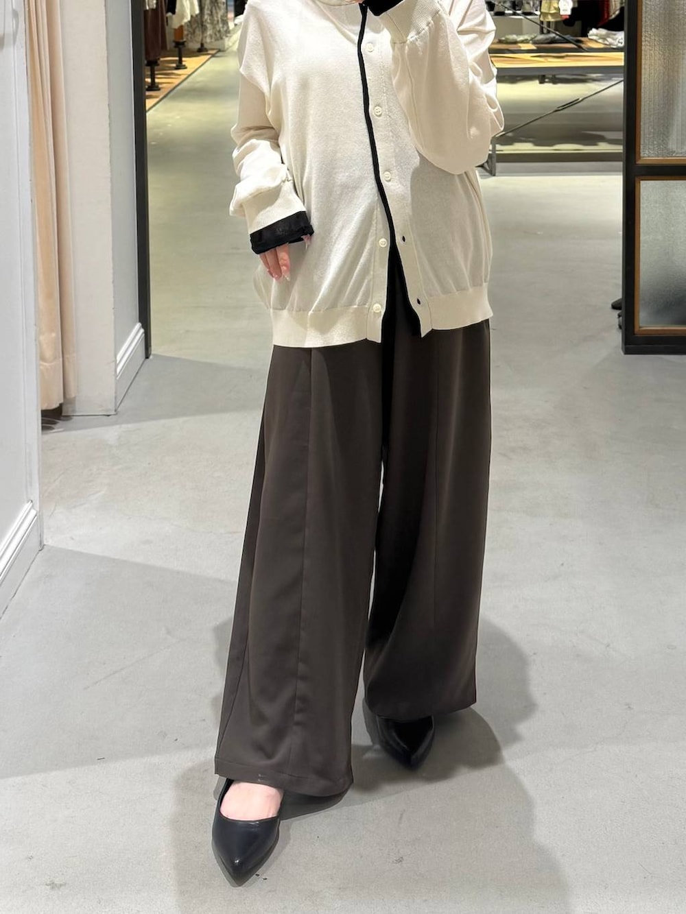 ブラウン系のその他パンツ、ブラック系のパンプス、ホワイト系のカーディガン/ボレロを着用したレディースの春コーディネートの4枚目の写真
