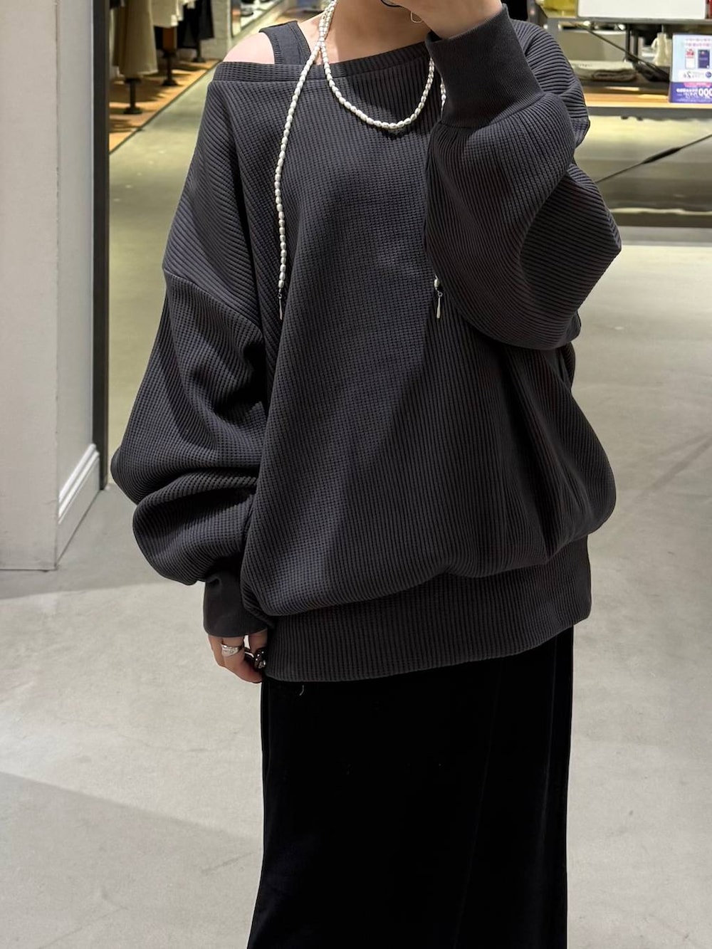 ブラック系のスカート、グレー系のTシャツ/カットソーを着用したレディースの冬コーディネートの2枚目の写真