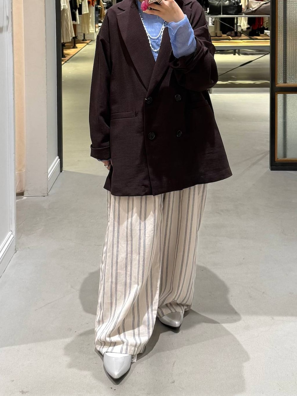 ブラウン系のテーラードジャケット、ブルー系のTシャツ/カットソー、シルバー系のパンプスを着用したレディースの春コーディネートの3枚目の写真