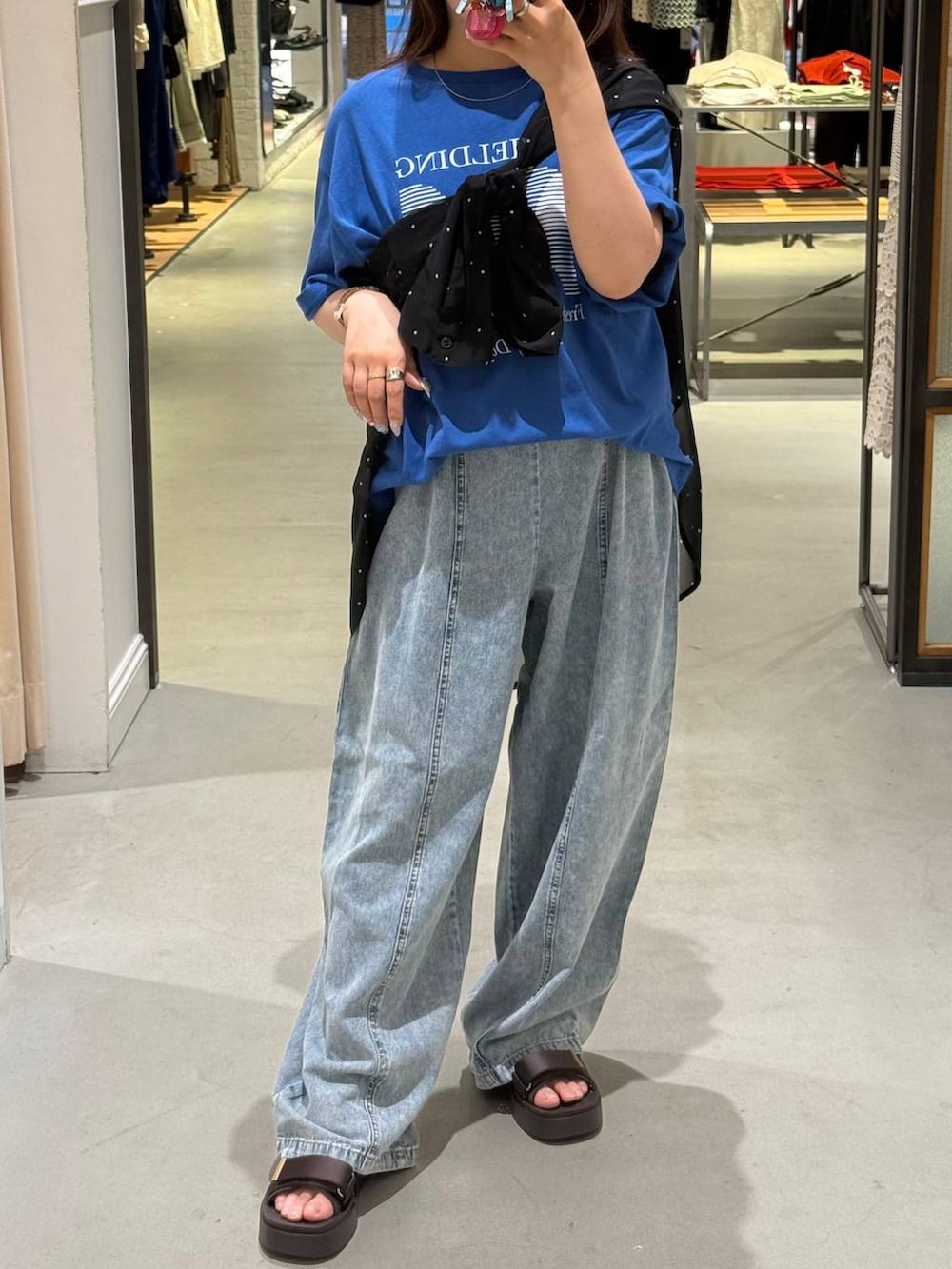 ブルー系のデニムパンツ、ブラック系のシャツ/ブラウス、ブラウン系のサンダルを着用したレディースの夏コーディネートの4枚目の写真