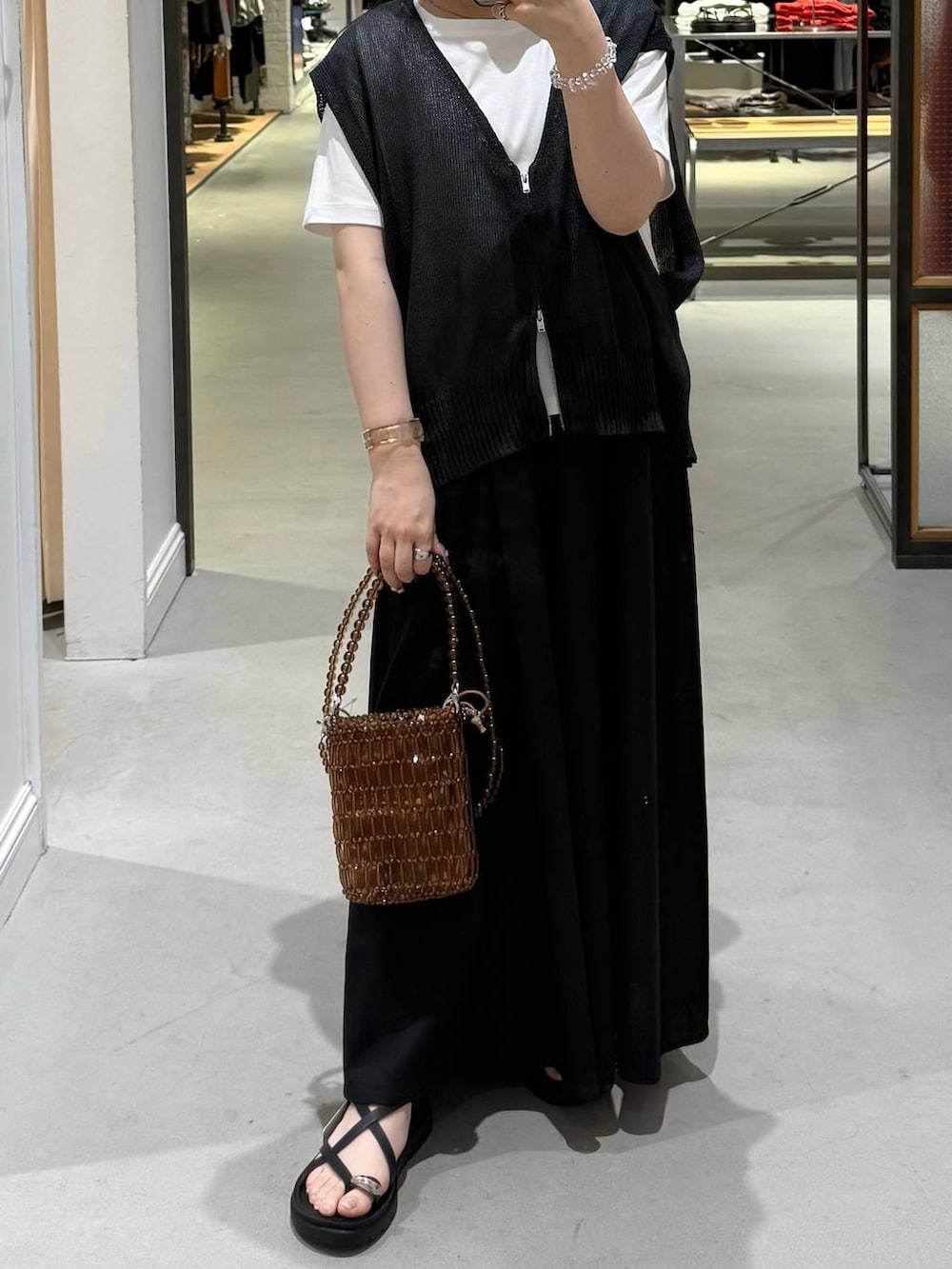 ブラック系のサンダル、ブラック系のその他パンツ、ホワイト系のTシャツ/カットソーを着用したレディースの春コーディネートの2枚目の写真