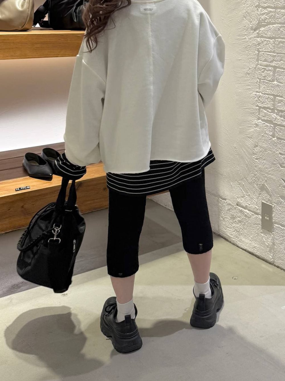 ブラック系のショルダーバッグ、ブラック系のTシャツ/カットソー、ブラック系のその他パンツを着用したレディースの冬コーディネートの4枚目の写真