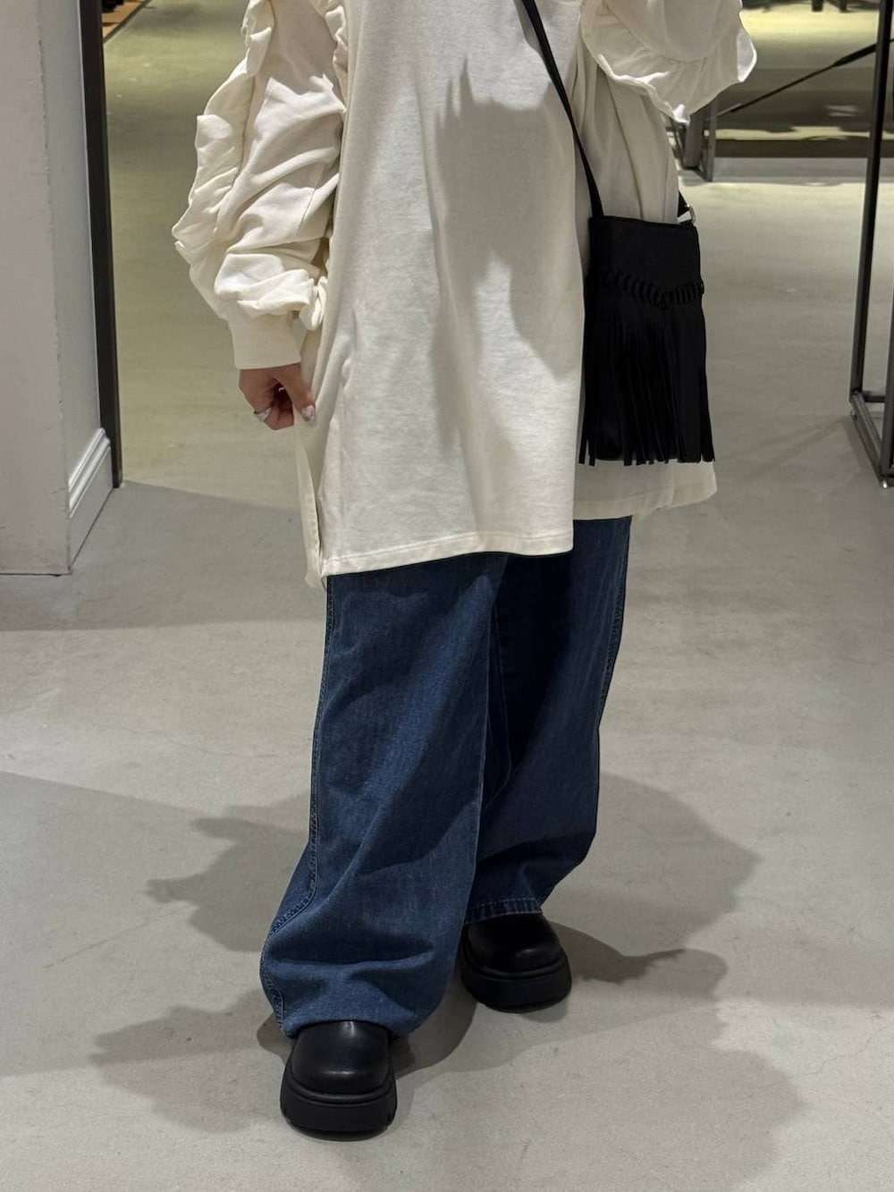 ブラック系のその他シューズ、ブラック系のショルダーバッグ、ブルー系のデニムパンツを着用したレディースの春コーディネートの2枚目の写真