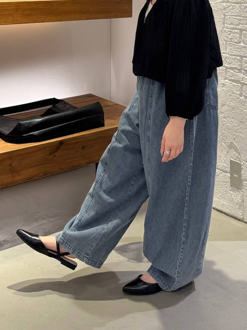 ブラック系のシャツ/ブラウス、ブラック系のショルダーバッグ、ブラック系のパンプスを着用したレディースの春コーディネートの2枚目の写真