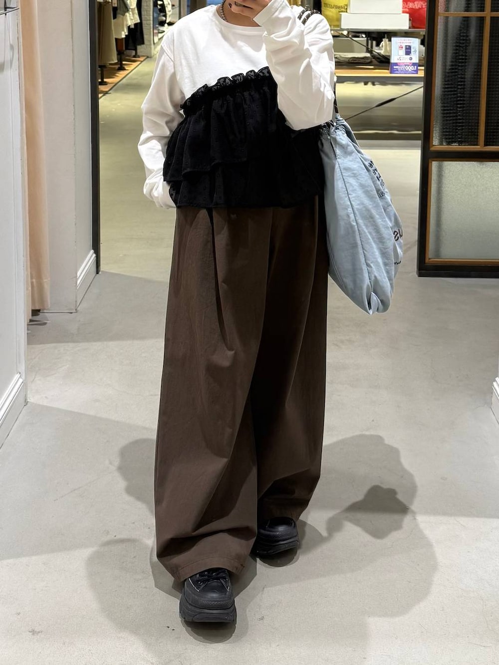 ブラウン系のその他パンツ、ブルー系のトートバッグを着用したレディースの冬コーディネートの4枚目の写真