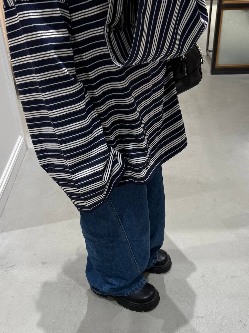 ブルー系のデニムパンツ、ブラック系のボストンバッグ、ブラック系のその他シューズを着用したレディースの冬コーディネートの3枚目の写真