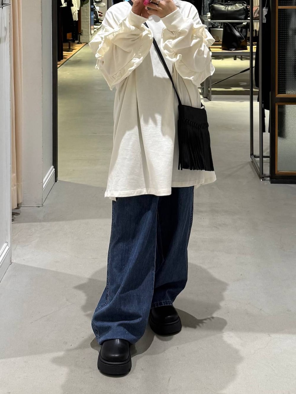 ブラック系のその他シューズ、ブラック系のショルダーバッグ、ブルー系のデニムパンツを着用したレディースの春コーディネートの3枚目の写真