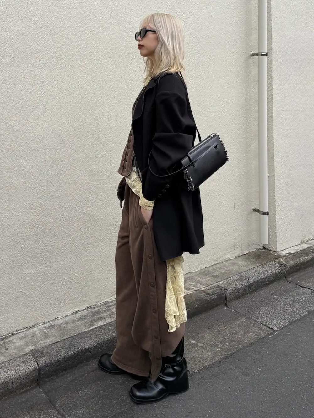 ブラウン系のスウェットパンツ、ブラック系のブーツ、ブラウン系のその他トップスを着用したレディースの春コーディネートの2枚目の写真